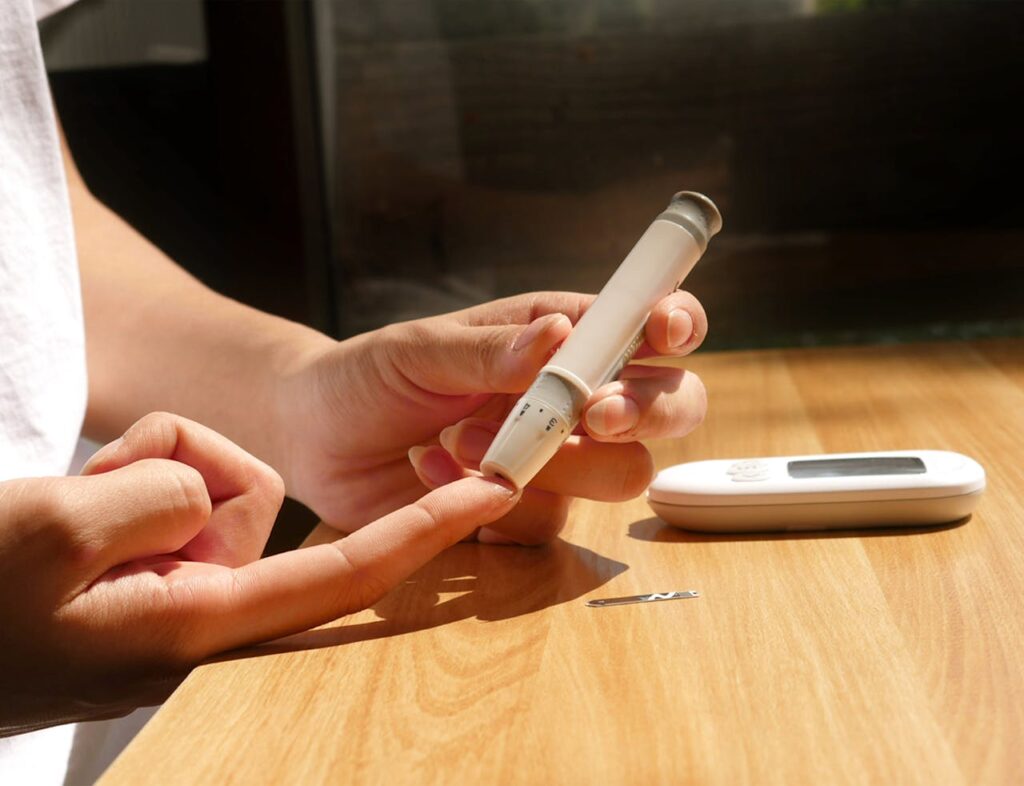 Close-up of hands using a blood glucose meter, showcasing diabetes management tools.