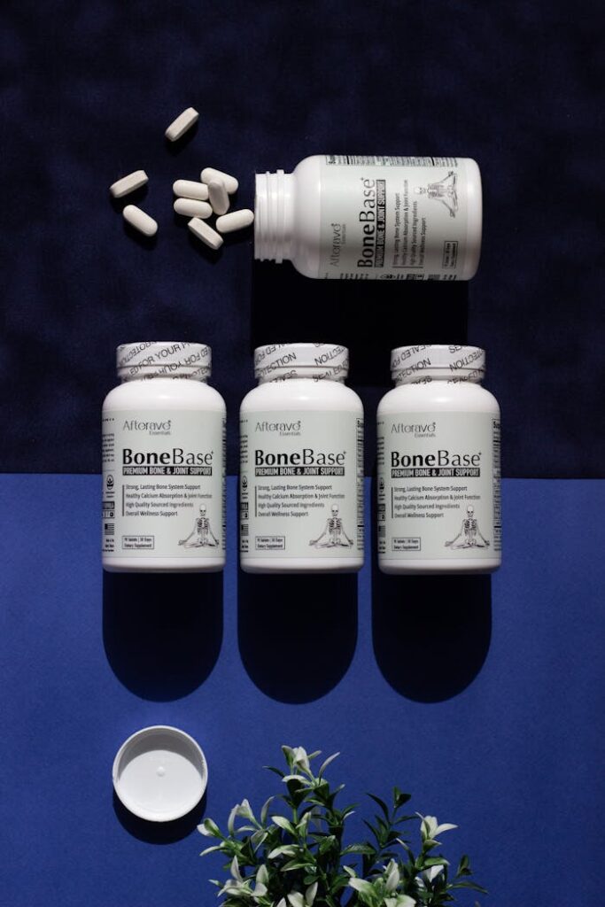 BoneBase supplement bottles and pills displayed on a contrasting blue surface.