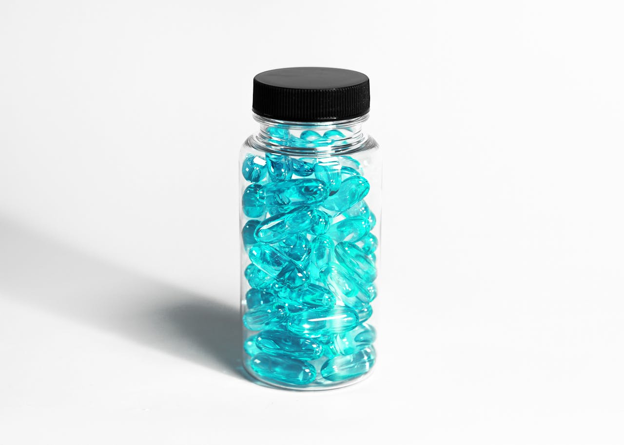 who-we-are-img A clear bottle filled with turquoise capsules, showcasing healthcare and nutrition themes.